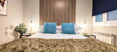 a bedroom with a large bed with blue pillows at Relaxing 3BR w terrace in heart of Gràcia - Bossa in Barcelona
