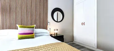 a bedroom with a bed with a pillow and a mirror at Relaxing 3BR w terrace in heart of Gràcia - Bossa in Barcelona