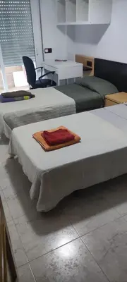 two beds in a room with a towel on them at Habitación en piso compartido in Terrassa