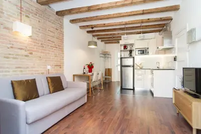 a living room with a couch and a brick wall at Apartments Barcelona Sagrada in Barcelona