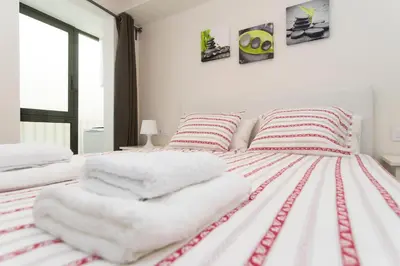 a bedroom with two beds with white and red stripes at Apartments Barcelona Sagrada in Barcelona