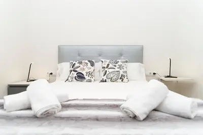 a white bedroom with a white bed with pillows at Apartments Barcelona Sagrada in Barcelona