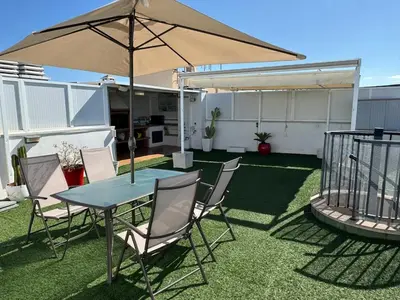 a patio with a table and chairs and an umbrella at Atico espectacular Cunit in Cunit