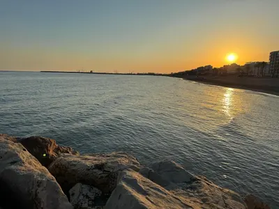 a sunset over a beach with rocks in the water at Atico espectacular Cunit in Cunit