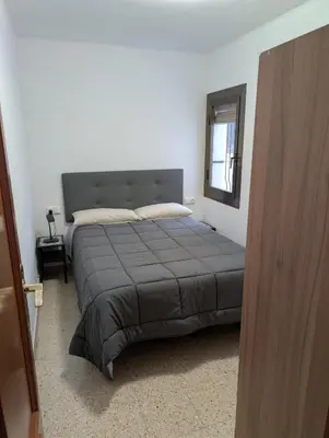 a bedroom with a bed and a mirror on the wall at Apartamento Barcelona in Hospitalet de Llobregat