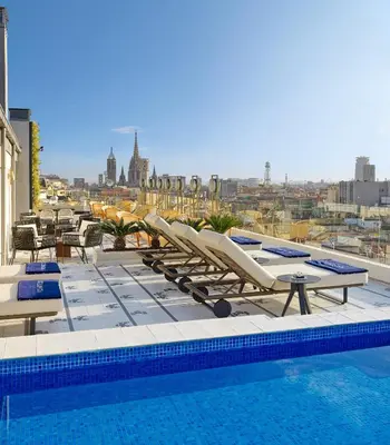 a pool with lounge chairs and a view of the city at H10 Cubik 4* Sup in Barcelona
