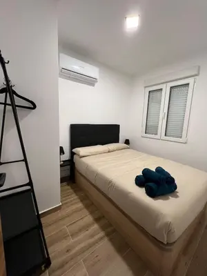 a bedroom with a bed with a blue robe on it at Modern apartment 2 Barcelona in Santa Coloma de Gramanet