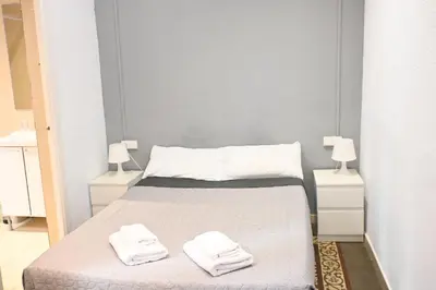 a bedroom with a bed with two towels on it at Homenfun Barcelona Camp Nou in Hospitalet de Llobregat