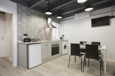 a kitchen with a table and chairs in a room at Stay U-nique Apartments Llobregat in Hospitalet de Llobregat