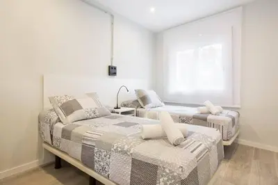 a bedroom with two beds and a window at Stay U-nique Apartments Llobregat in Hospitalet de Llobregat