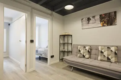 a living room with a couch and a bed at Stay U-nique Apartments Llobregat in Hospitalet de Llobregat