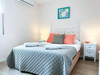 a bedroom with a large bed with orange and gray pillows at Apartment Sunset in Cunit
