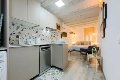 a kitchen with white cabinets and a bed in a room at Acogedor y céntrico Estudio 1 in Barcelona