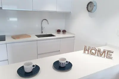 a kitchen with two cups and saucers on a counter at Rooftop pool near the beach and Barcelona in Masnou
