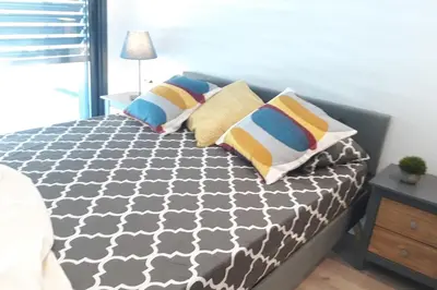 a bed with pillows on it in a bedroom at Rooftop pool near the beach and Barcelona in Masnou