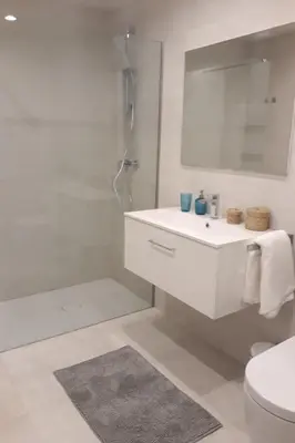 a white bathroom with a sink and a shower at Rooftop pool near the beach and Barcelona in Masnou