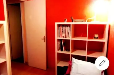 a room with a red wall and a book shelf at 3rooms, 10 minAirport, free parking, public transp in Cornellà de Llobregat