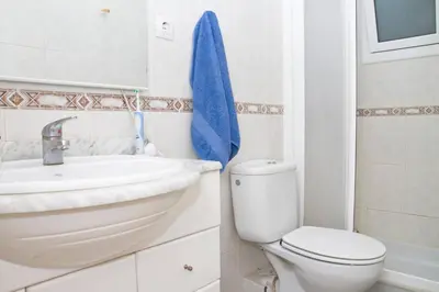 a bathroom with a toilet sink and a blue towel at 3rooms, 10 minAirport, free parking, public transp in Cornellà de Llobregat