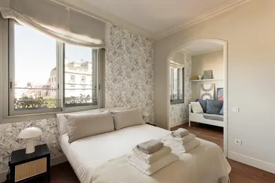 a bedroom with a white bed and a large window at Enjoy Apartments Augustina's Grand Family Suite in Barcelona