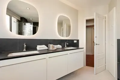 a white bathroom with two sinks and two mirrors at Enjoy Apartments Augustina's Grand Family Suite in Barcelona