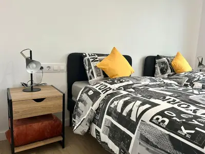 a bedroom with a bed and a table with a lamp at Les Flors de Cunit Villa Edelweiss in Cunit