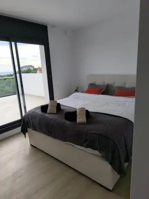 a bedroom with a bed and a large window at Les Flors de Cunit Villa Edelweiss in Cunit