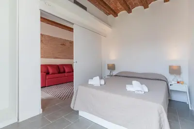 a bedroom with a bed and a red couch at Aparteasy - Deluxe Family Apartments with Pool in Barcelona