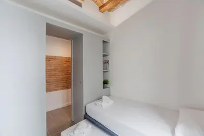 a bedroom with white walls and a bed in a room at Aparteasy - Deluxe Family Apartments with Pool in Barcelona