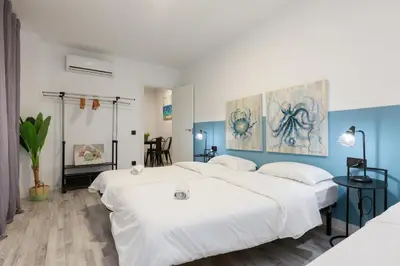 a bedroom with two beds and a painting on the wall at matarolux21 in Mataró