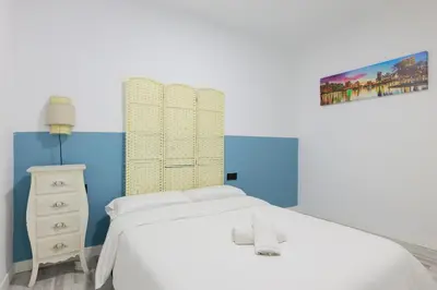 a bedroom with a white bed and a painting on the wall at matarolux21 in Mataró