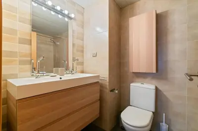 a bathroom with a toilet and a sink and a mirror at Modern Spacious 3-Bedroom Apt with Pool near Beach in Barcelona