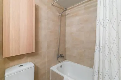 a bathroom with a toilet and a shower curtain at Modern Spacious 3-Bedroom Apt with Pool near Beach in Barcelona