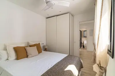 a bedroom with a bed with white sheets and pillows at The Sweet House - BBQ y piscina in Sant Cugat del Vallès