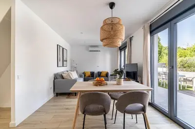 a dining room and living room with a table and chairs at The Sweet House - BBQ y piscina in Sant Cugat del Vallès