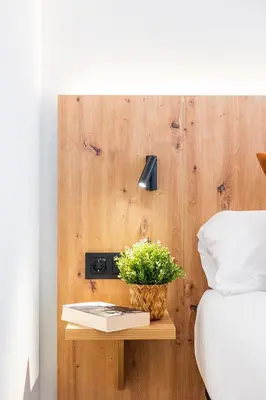 a table with a plant on it next to a bed at Brabo Apartments in Hospitalet de Llobregat