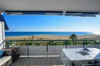 a balcony with a table and a view of the beach at Winahost El balcón al mar de Cubelles in Cubelles