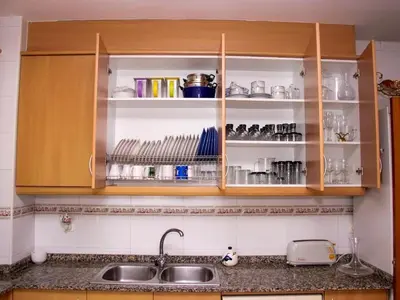 a kitchen with wooden cabinets and a sink at Winahost El balcón al mar de Cubelles in Cubelles