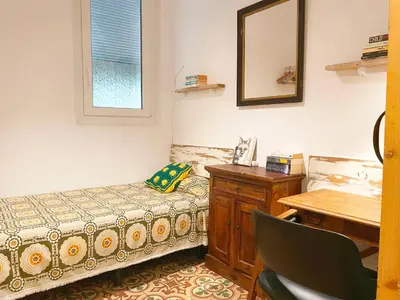 a room with a bed and a desk and a mirror at Vintage home in Barcelona