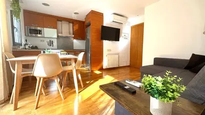 a living room and kitchen with a couch and a table at Acogedor apartamento by Prestigi in Terrassa