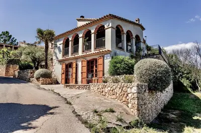 a large house with a stone fence and a road at Montrural in Castellví de la Marca