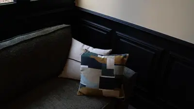 a pillow sitting on a couch next to a wall at Boada Riera - The RoomsbyReini in Terrassa