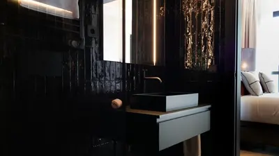 a bathroom with a sink and a black wall at Boada Riera - The RoomsbyReini in Terrassa