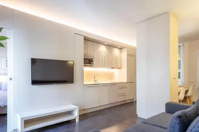 a kitchen and dining room with a white table and chairs at BCN MONTJUÏC Apartments in Barcelona