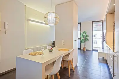 a kitchen and living room with a table and chairs at BCN MONTJUÏC Apartments in Barcelona