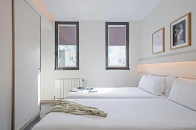 a white bathroom with a sink and a mirror at BCN MONTJUÏC Apartments in Barcelona