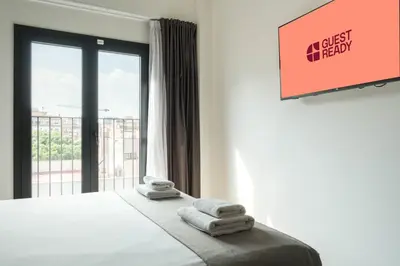 a room with a bed with towels on it with a window at GuestReady - ARIQUS Apartments in Barcelona