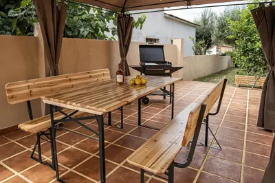 a table and benches on a patio with a television at Cal Sopas in Collbató