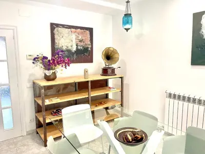 a dining room with a glass table and white chairs at Camins de Montserrat in El Bruc
