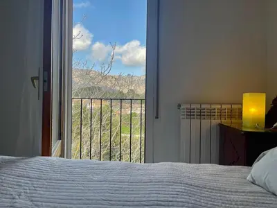 a bedroom with a bed and a window with a view at Camins de Montserrat in El Bruc