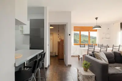 a kitchen and living room with a couch and a table at Mima House with Pool in Canyelles